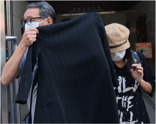 次被告(右)離開法官時以衫遮掩。