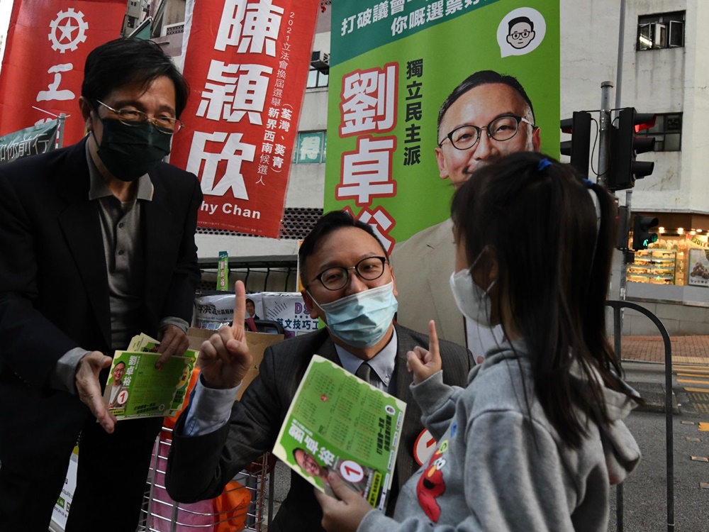 兩人一同在街站派傳單拉票。