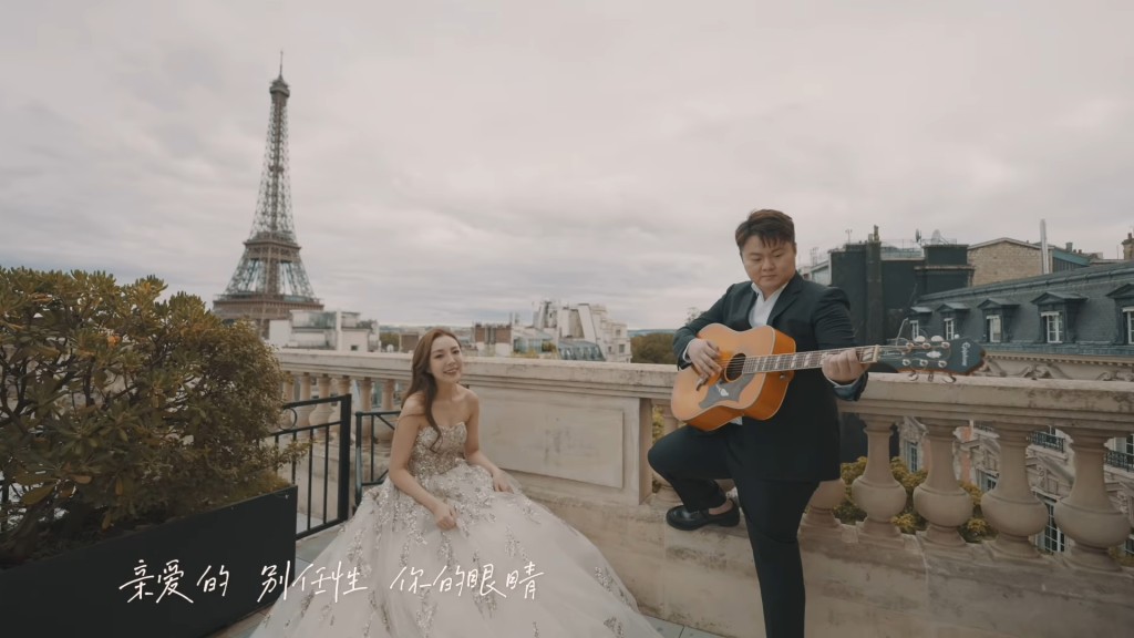 一对新人在巴黎铁塔背景下，大唱情歌。