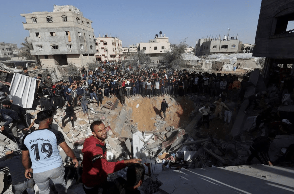 11 月23 日，以色列與哈馬斯在加沙持續衝突，巴勒斯坦人聚集在以色列襲擊拉法一所房屋的現場，其他人在尋找傷亡人員。路透社