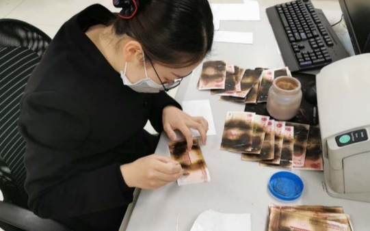 銀行職員逐張仔細揭開檢查、鑑定及點算,最終為她換上新紙幣。網圖