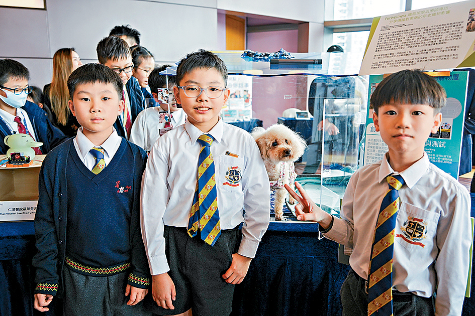 圣若瑟英文小学学生吴一信（左起）、林轩浚与吴梓维设计的「智创宠物屋」，让患病的宠物毋须与饲主分离亦能养病。林轩浚昨带同爱犬出席启动礼。