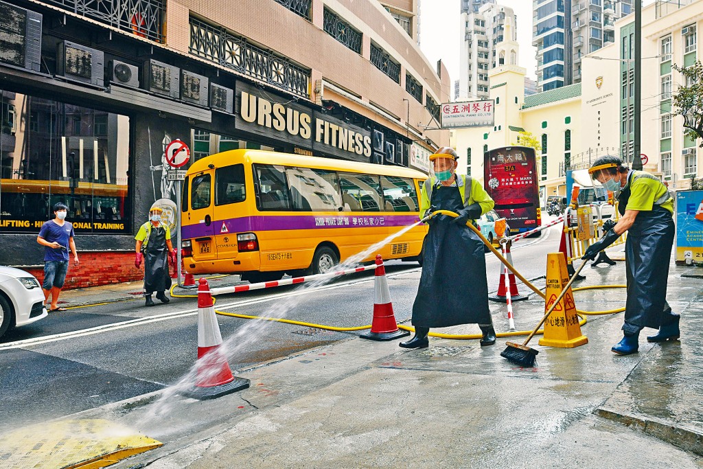 ■URSUS Fitness爆疫不斷，昨再有逾六十宗相關個案出現。圖為戴了防護裝備的外判清潔工在該中心外洗地。