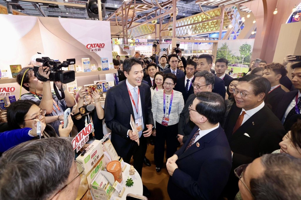 李家超（右二背身）下午在丘應樺和貿發局主席馬時亨陪同下，到貿發局在企業商業展設立的香港食品館和香港服務業展館參觀。李家超FB圖片