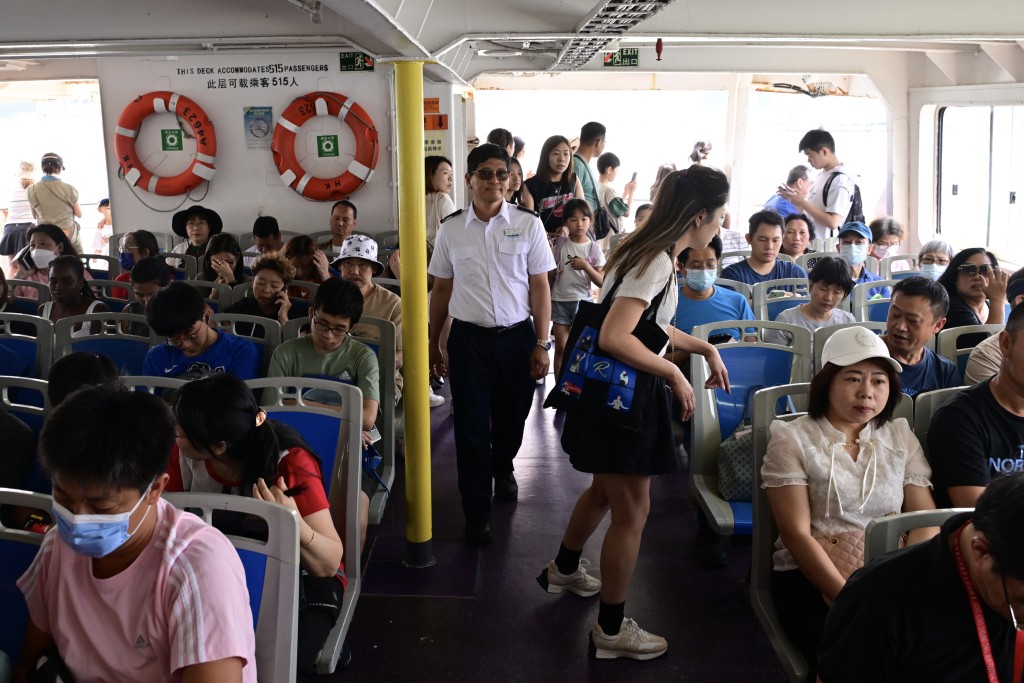 至中午，入长洲人潮继续增加，中环码头大批市民排队搭船，有乘客未能找到座位。（陈极彰摄）