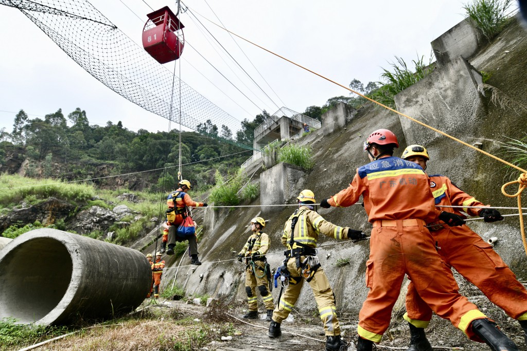 「山岳高空绳索T型救援」模拟山谷内建筑物废墟有人员被因，救援人员利用两侧建筑设置绳索锚点，制作成T型系统。卢江球摄