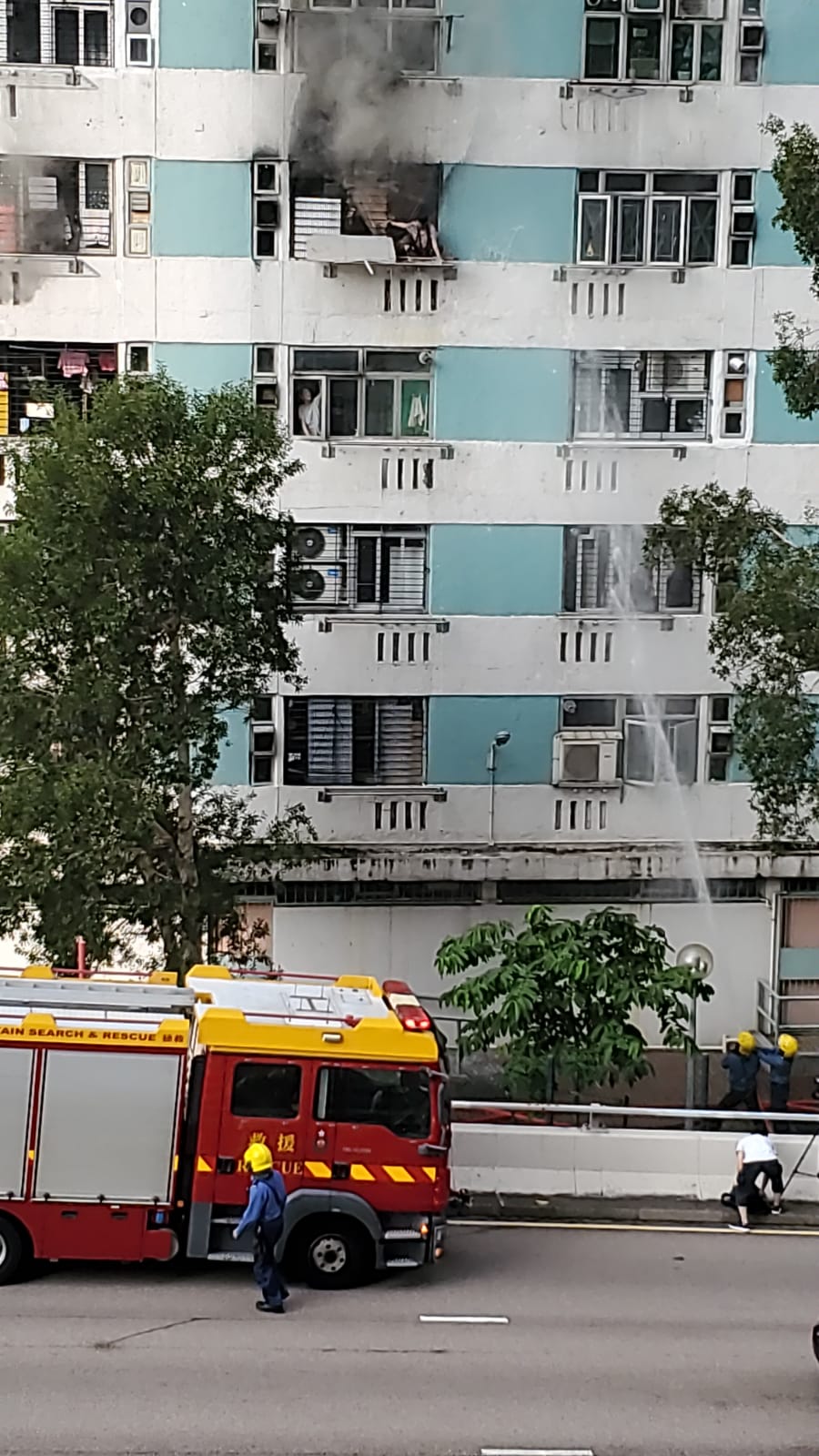 婦人危坐在窗口邊待救。圖:讀者提供