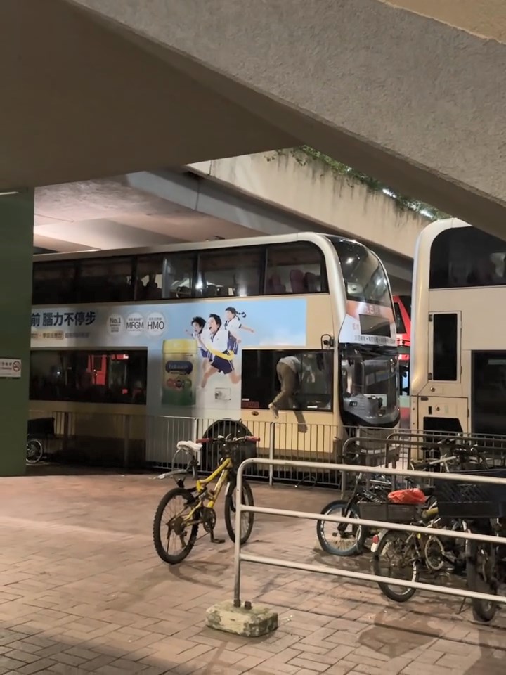 灰衫男小心翼翼從小窗爬入巴士內。網上片段截圖 灰衫男小心翼翼從小窗爬入巴士內。網上片段截圖
