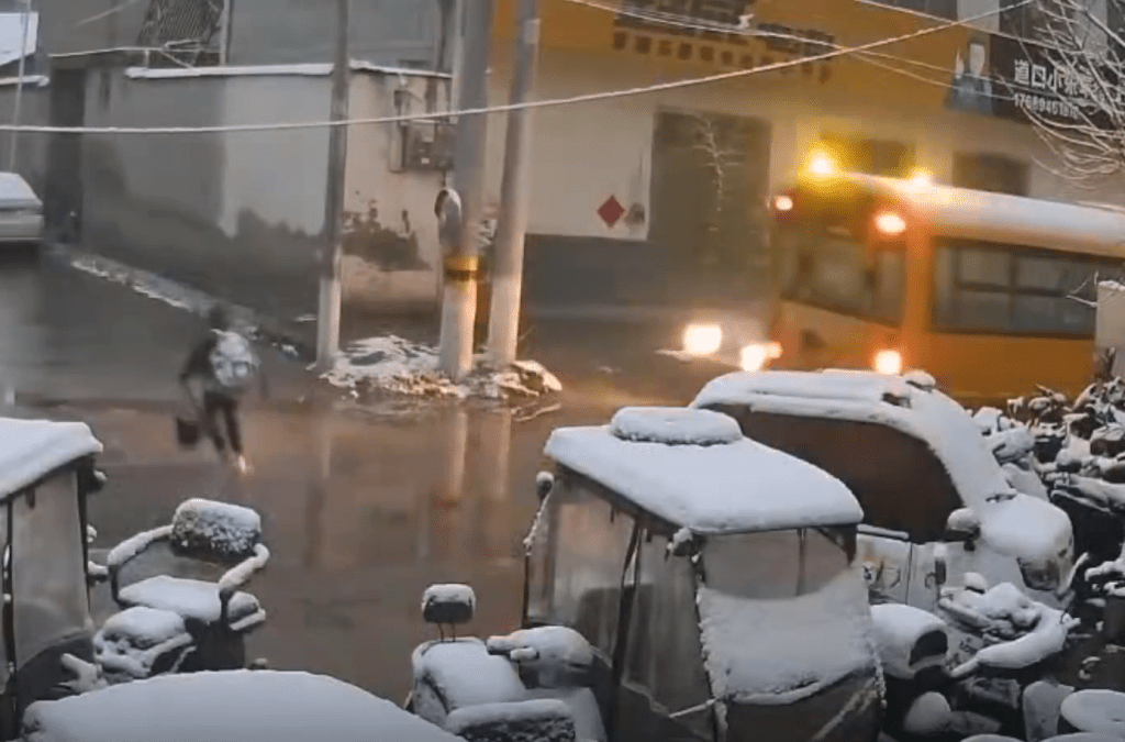 男童過馬路時,一輛小貨車從校車對線駛出。 男童過馬路時,一輛小貨車從校車對線駛出。