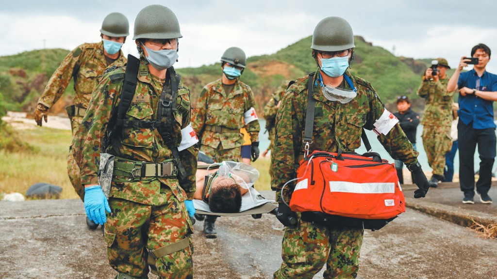 日本加速研究如台海发生事端时的应变计划。图为日本自卫队演习撤离国民情况。路透社