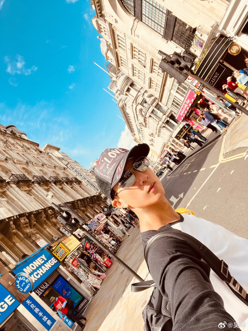 吴尊在伦敦街头拍照。