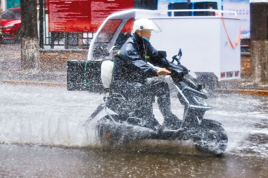 北京突降大雨，外卖员冒雨工作。