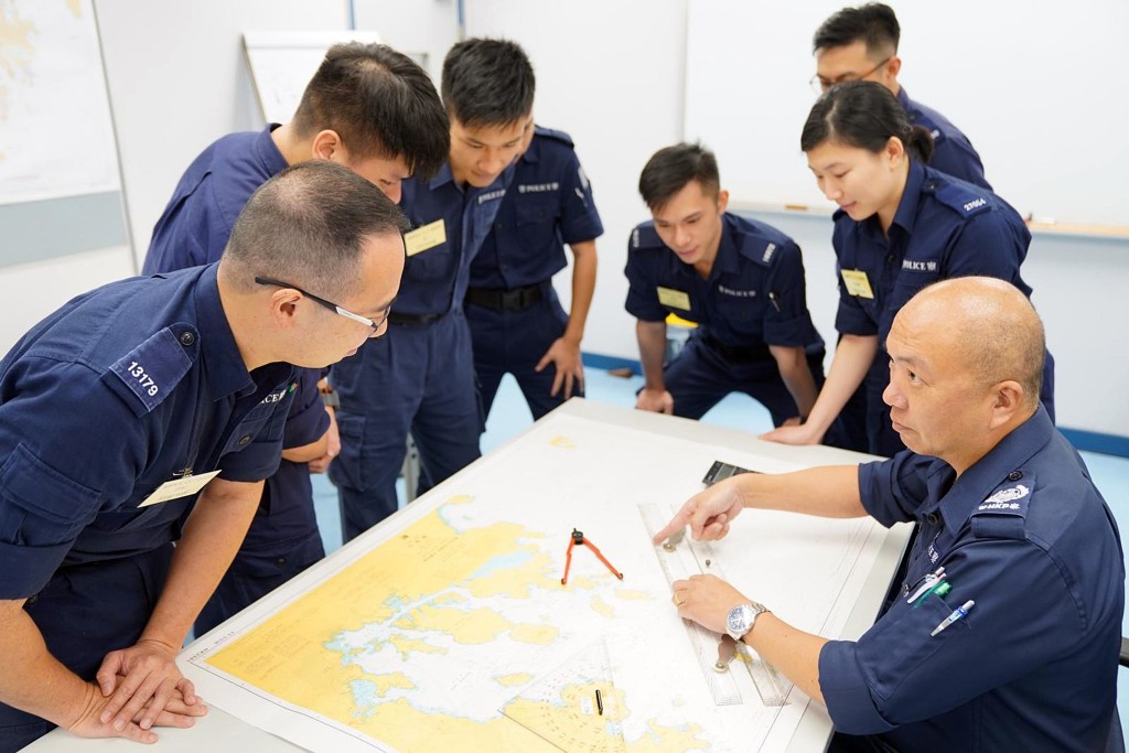 警署警長方建忠(右一)向學員講解船務知識和海事法例，致力讓新加入的學員從「白紙」變成具備專業能力的水警。