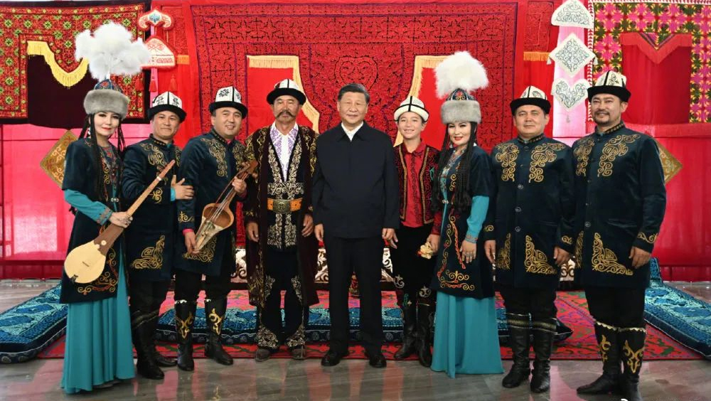 習近平同《瑪納斯》非物質文化遺產傳承人合影留念。新華社圖片