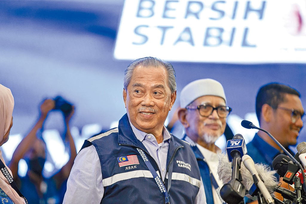 國盟主席穆希丁（左）周日獲悉大選結果時，面露笑容。