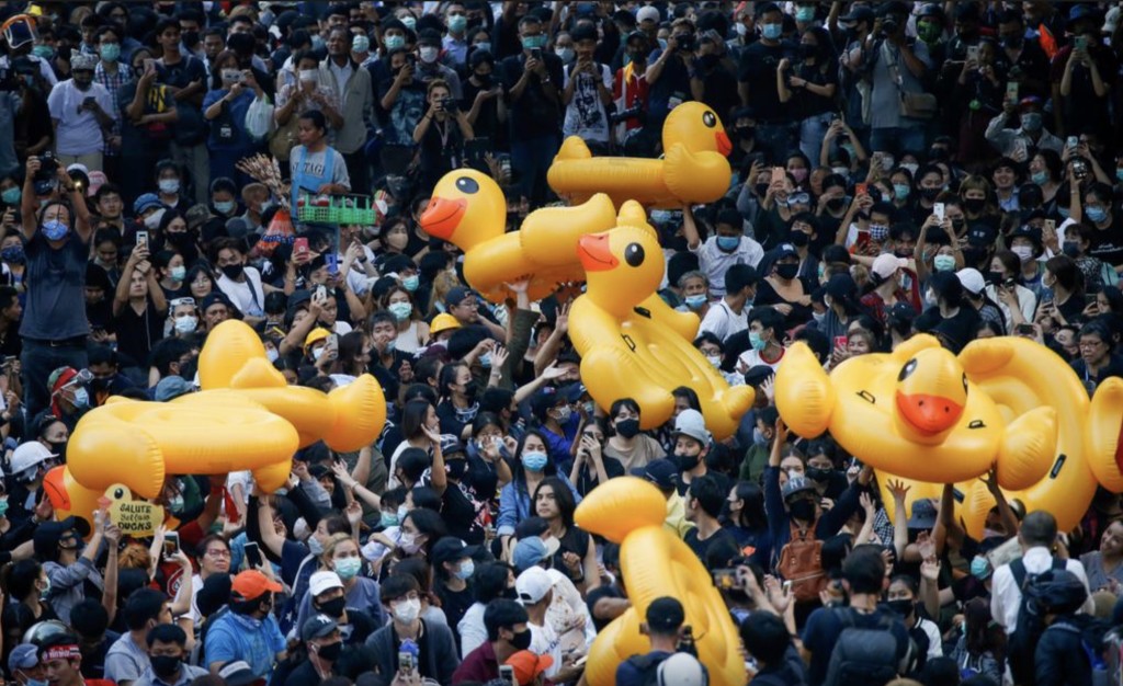 2020至2022年泰国爆发反政府示威潮，示威者传递用来抵挡水炮的巨型吹气黄鸭。 路透社