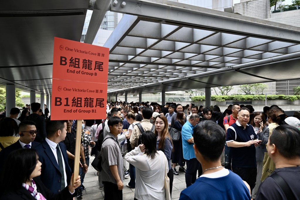 首岸發展商職員需舉牌提示輪候準買家龍尾位置，氣氛相當熱鬧。