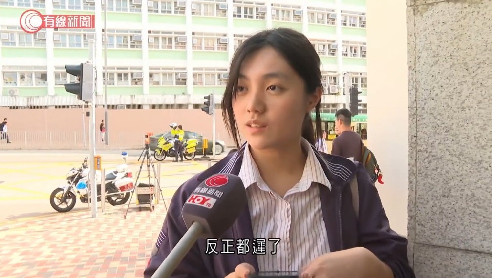 女生Ella在鏡頭前氣定神閒，一句「反正都遲了」網上爆紅。有線新聞片段截圖