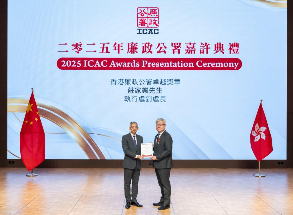 廉政專員胡英明(左)頒發紀念品予早前獲政府頒發廉政公署卓越獎章的執行處處長(私營機構)莊家樂(右)。ICCA圖片