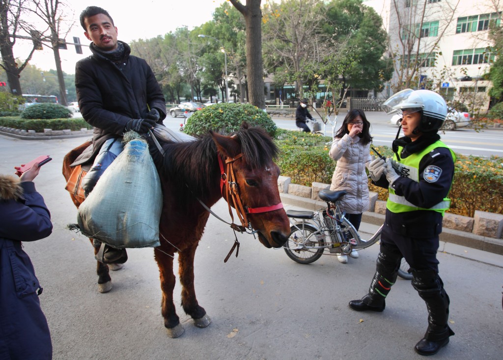 2012年唐新宇骑马途径济南市区，引来不少人的关注。 中新社
