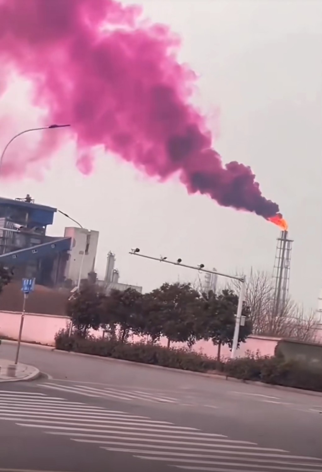 化肥厂烟囱冒出大量紫色烟雾。