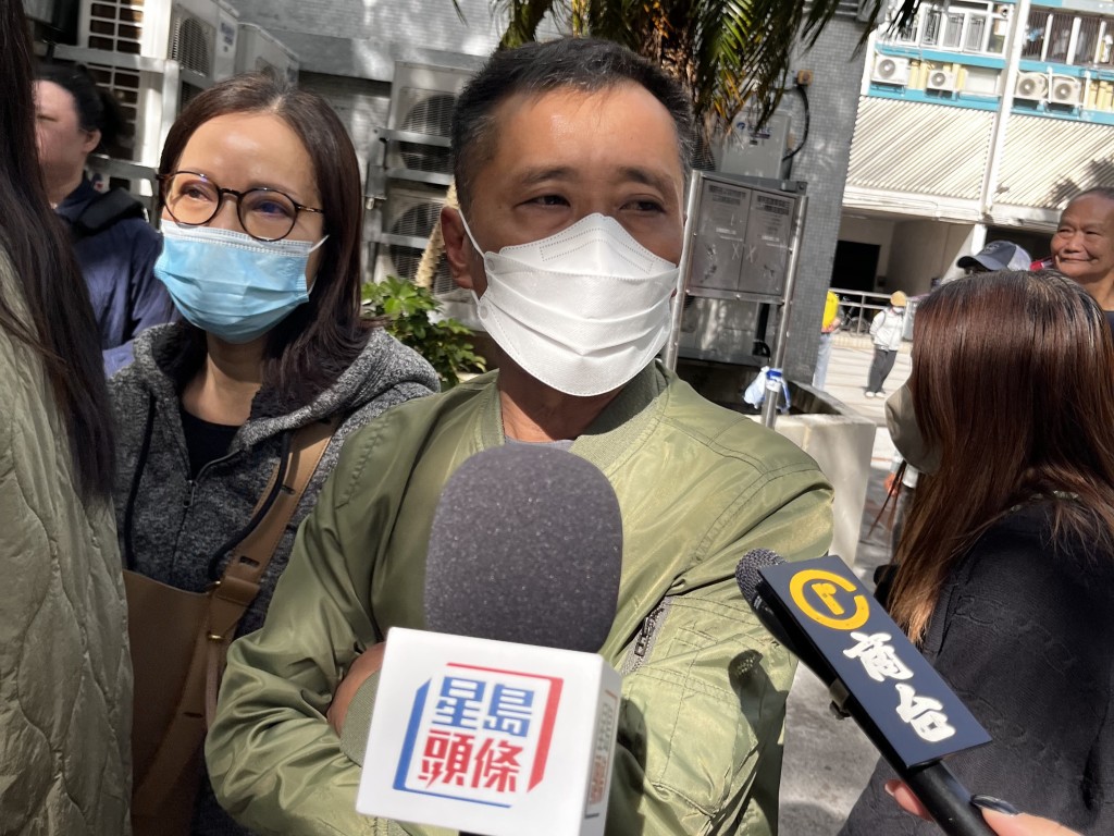 胡生及太太今早前來排隊準備進入社區中心認屍。李健威攝