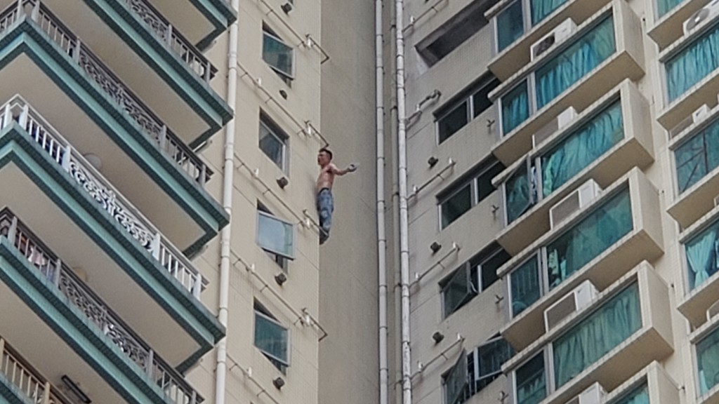 男子在大廈外牆攀爬，險象環生。蔡楚輝攝