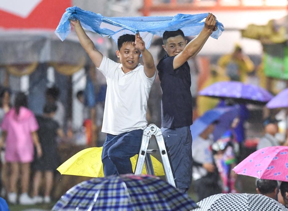  6月23日，觀眾冒雨觀看球賽。新華社