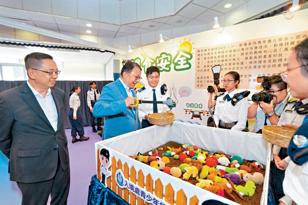 陳國基在入境處處長郭俊峯陪同下參觀展覽攤位，並親身試玩。