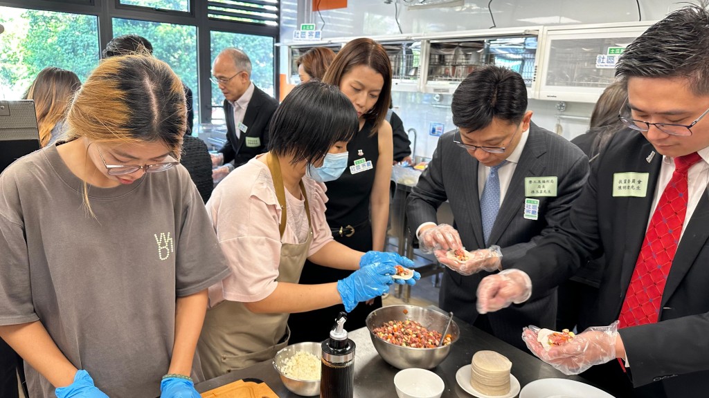 孫玉菡（右二）在共享備餐間與受惠家庭製作小食。政府新聞處