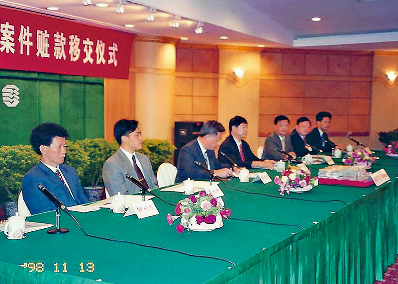 袁旭健（左二）出席1998年德福花园谋杀案的赃款移交仪式。《警声》图片