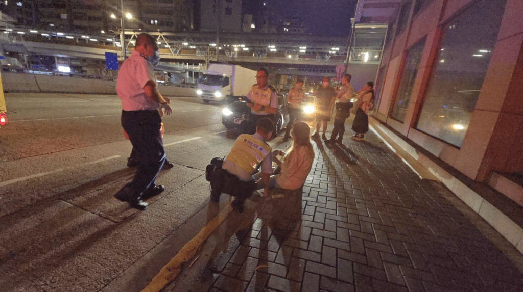 女子坐在行人路邊,向警員講述事發經過。黎志偉攝 女子坐在行人路邊,向警員講述事發經過。黎志偉攝