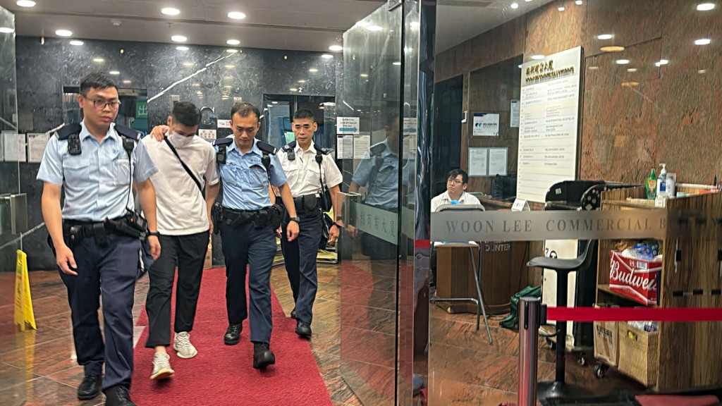 警員帶走一名欠交罰款男子。劉漢權攝 警員帶走一名欠交罰款男子。劉漢權攝