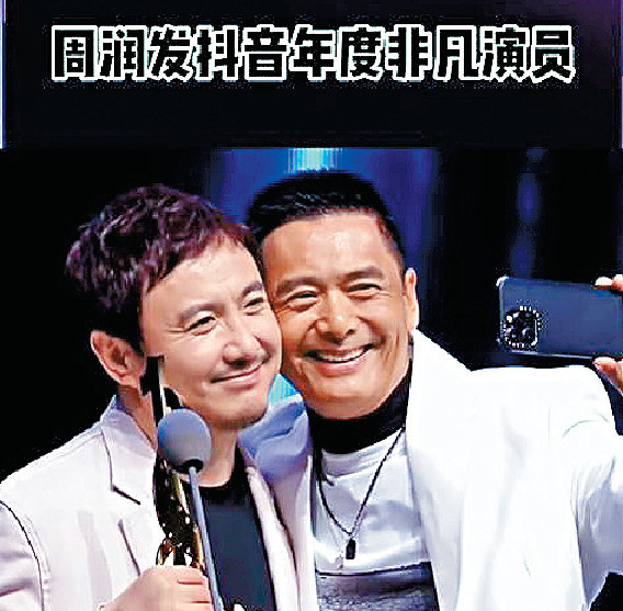 ■周潤發上台領獎時跟嘉賓沈騰頭貼頭自拍。 ■周潤發上台領獎時跟嘉賓沈騰頭貼頭自拍。