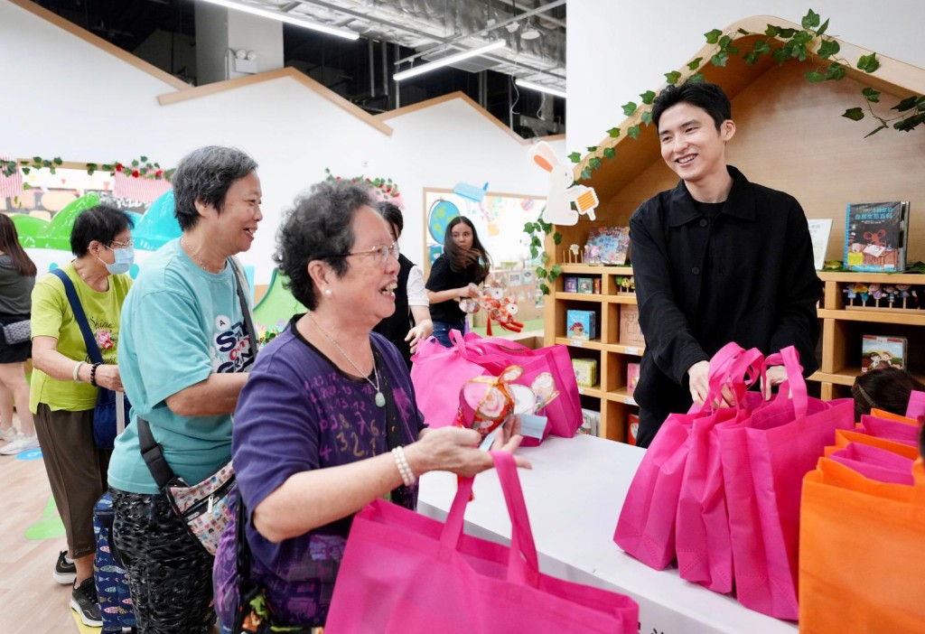 香港各界扶貧促進會會長兼召集人蔡加讚（右）向長者派發禮物包。