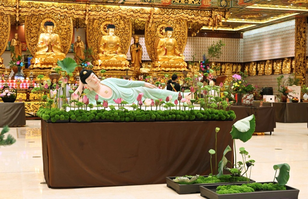 萬佛寶殿的臥佛四周圍滿了蓮花，以鮮花供佛。