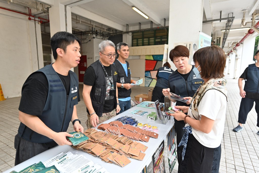 海關人員向居民介紹海關打擊私煙的工作。 海關人員向居民介紹海關打擊私煙的工作。