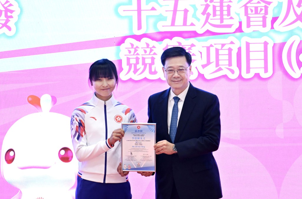 李思穎在單車項目取得三金，是本屆全運會奪金最多香港選手。她從李家超手中接過表揚狀。