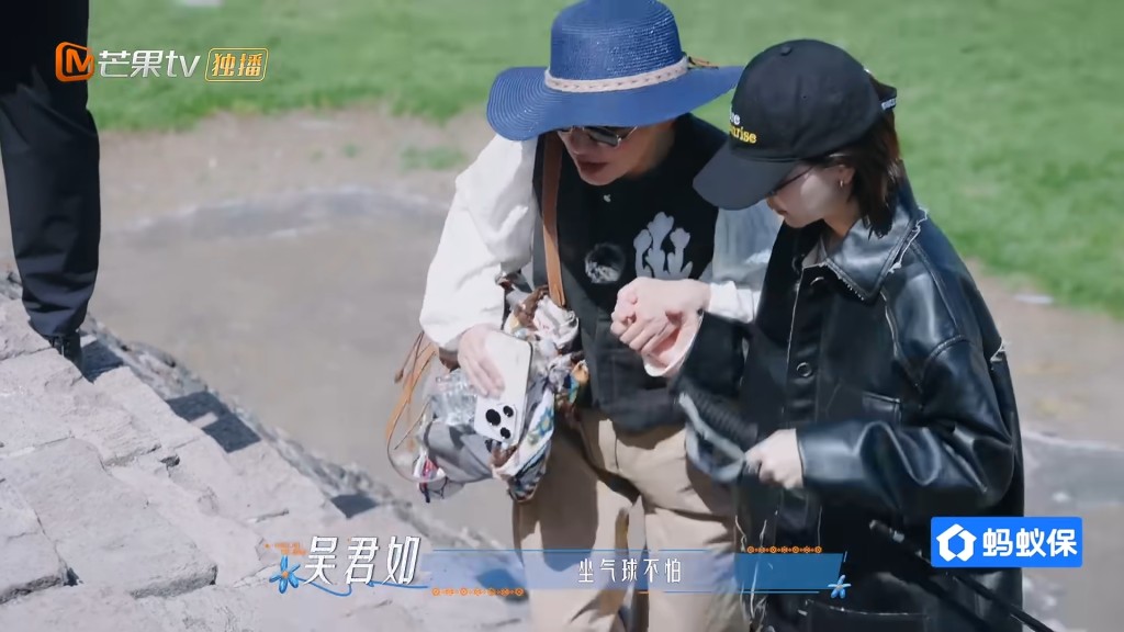 周冬雨寸步不離緊緊牽著吳君如的手，小心翼翼攙扶她沿著陡斜石階往下走。