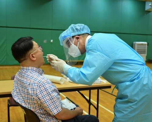 許樹昌及梁卓偉先後穿上保護衣、戴上手套及面罩等,為對方進行採樣