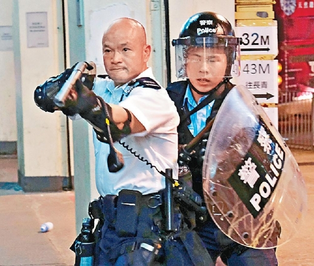 有「光頭警長」之稱的劉澤基因舉雷明登霰彈槍嚇退人群「成名」。 資料圖片