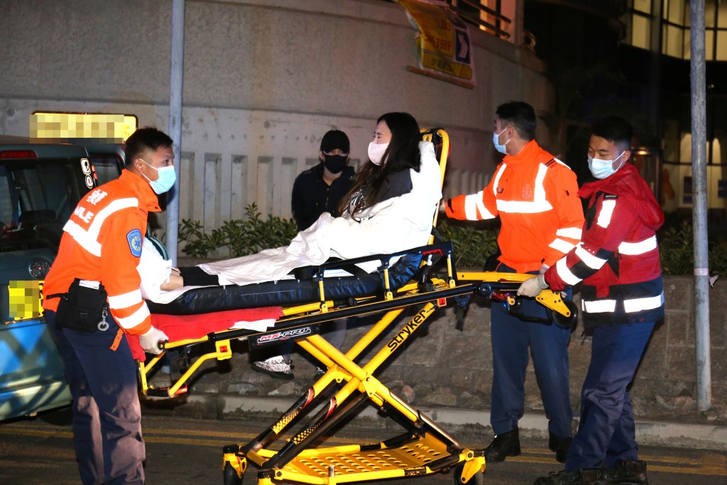 救護員將其中一名受傷女乘客送上救護車。