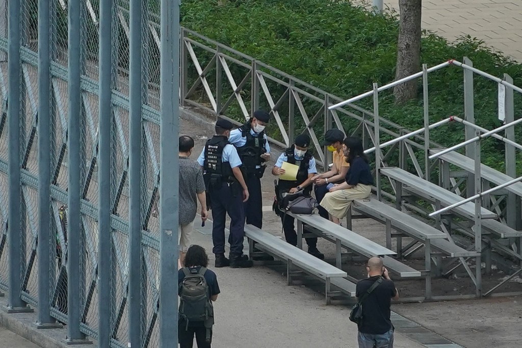 警员搜查在公园内的市民。