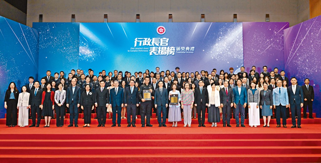 行政長官李家超（中）與獲獎的「處理戰時炸彈跨部門行動及支援組」、「簡約公屋項目跨部門團隊」，及一眾官員合照。