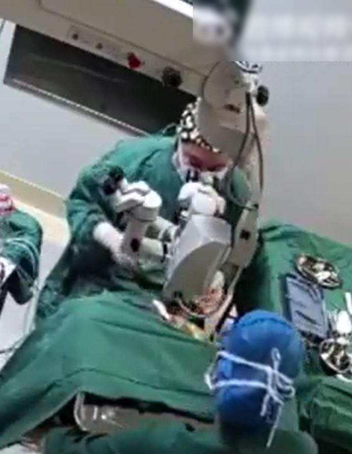 手术途中，医生拳击患者头部。影片截图