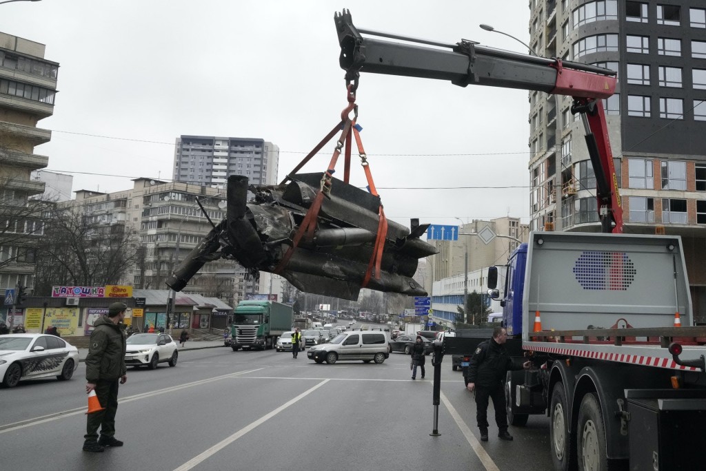 在首都基輔，工人吊走受襲後遺下的火箭彈碎片。AP