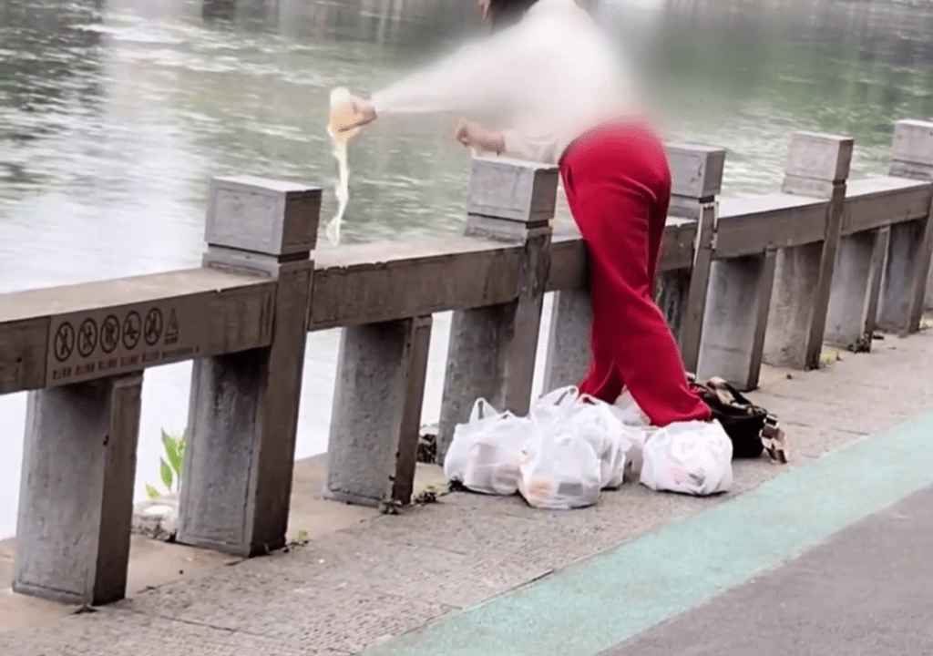 貴州女子在河邊將一杯一杯的奶茶「放生」。