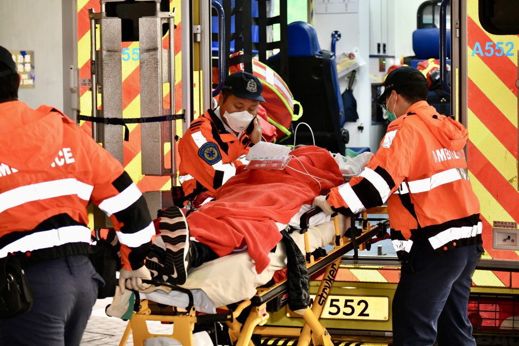 有傷者被消防救護車送入醫院，面部和手部皮膚被熏黑，胸口掛有「第一優先」胸牌。盧江球攝