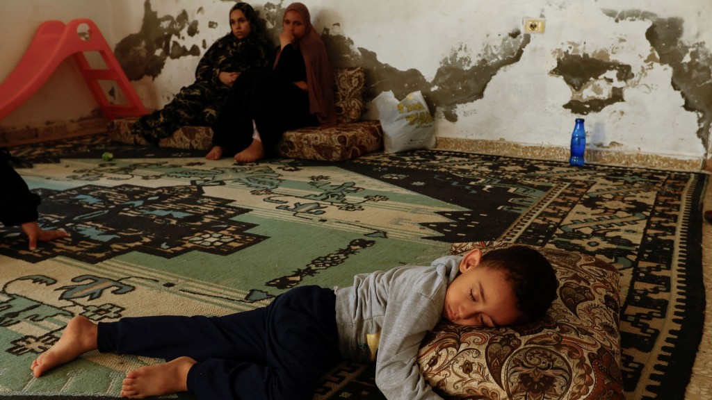巴勒斯坦妇女和小孩逃离住所，在一间幼稚园避难。 路透社