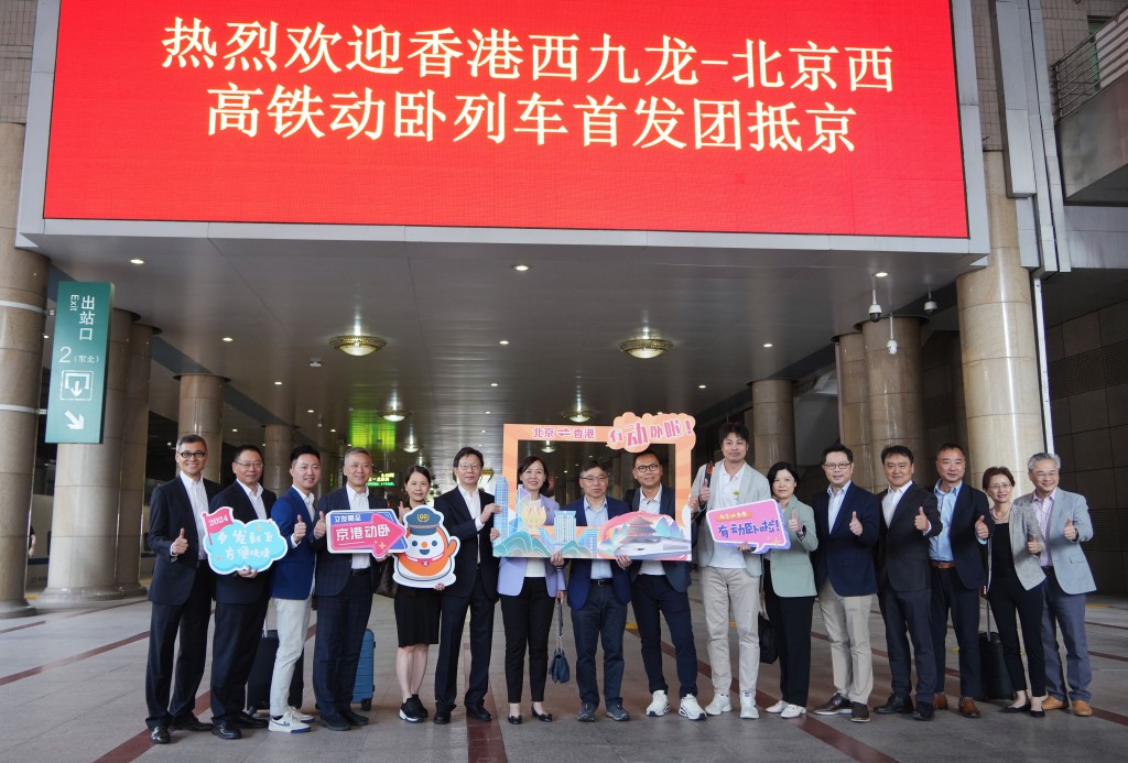 试坐首发高铁卧铺列车的运输及物流局局长林世雄（左8）抵达北京西站。资料图片